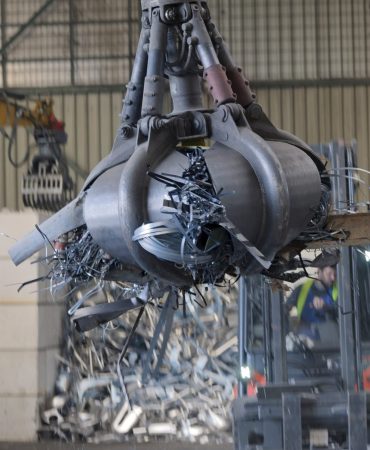 clamshell-grabbing-scrap-in-a-scrap-metal-recyclin-KKX8Y4W